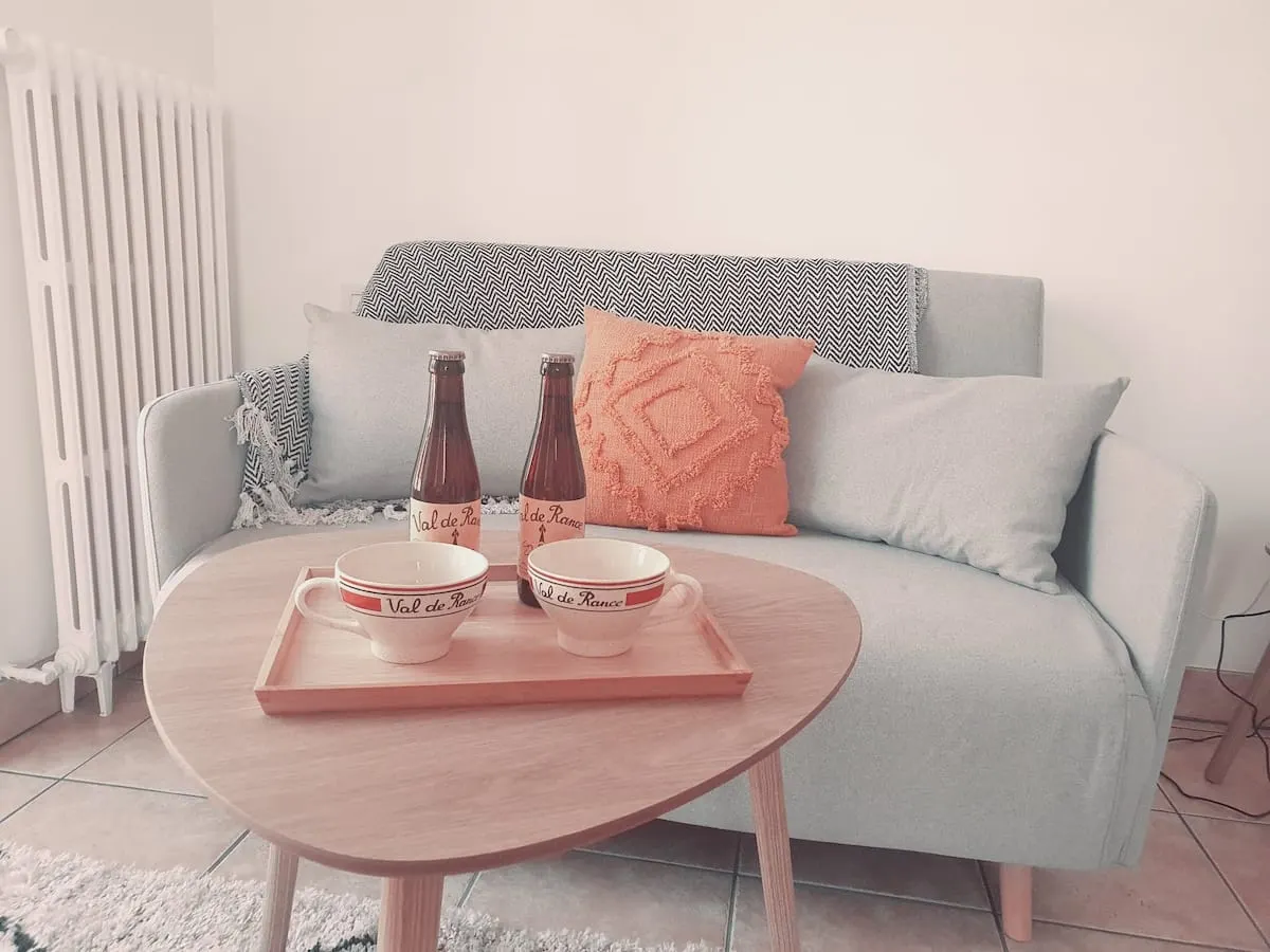 Le petit cocon — salon avec canapé et plateau de bienvenue